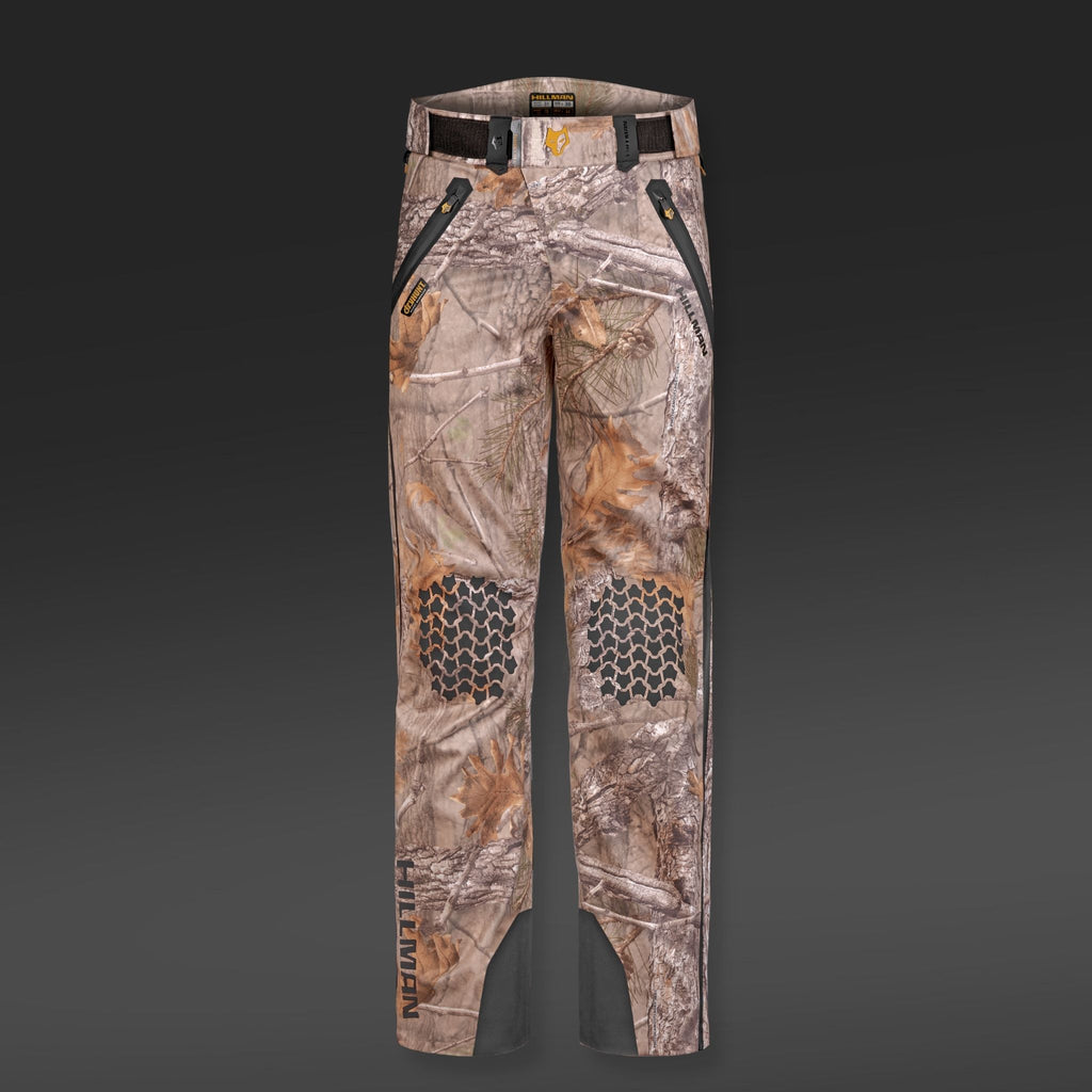 Die Hillman 5WL Camouflage Regenhose ist eine ultraleichte, wasserdichte Jagdhose mit schwarzen Akzenten, Reißverschlusstaschen und verstärkten Kniebereichen mit sechseckigem Muster und Gürtelschlaufen. Diese Hose zeichnet sich durch ein robustes Design aus, das sich ideal für verschiedene Outdoor-Aktivitäten eignet.